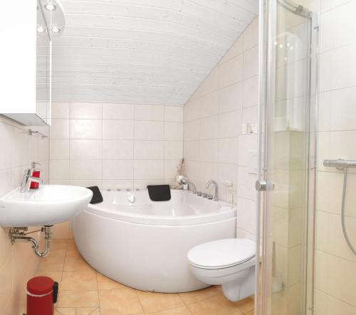 La salle de bains est pourvue d'une baignoire, de toilettes et d'un lavabo. dans l'établissement Dänische Ferienhäuser am Salzhaff Haus Vogelparadies, à Poel