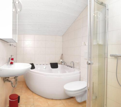 une salle de bain avec une baignoire, des toilettes et un lavabo dans l'établissement Dänische Ferienhäuser am Salzhaff Haus Vogelparadies, à Poel