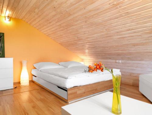 a bed in a room with a wooden ceiling at Hus in de Sünn in Insel Poel