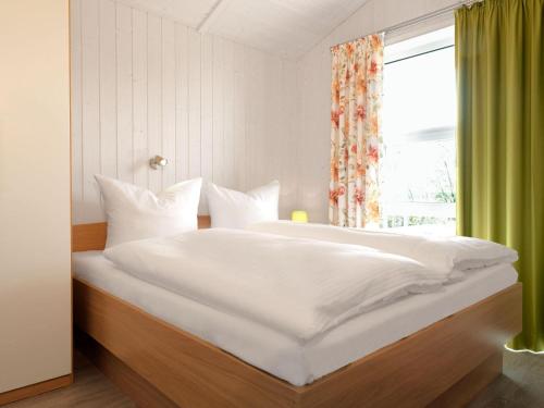 En eller flere senge i et værelse på Dänische Ferienhäuser am Salzhaff Haus Wassermann