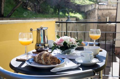 a table with a breakfast of bread and orange juice at Pagu Pagu de Paradisu - A little bit of paradise in Gàiro SantʼElena