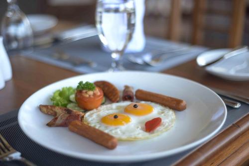 a plate of breakfast food with eggs and bacon at Kandy Hills in Kandy