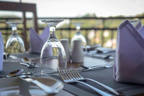 a table with silverware and a glass bottle on it at Kandy Hills in Kandy