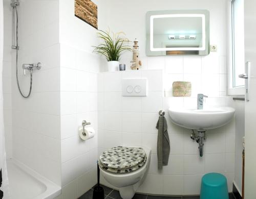 a white bathroom with a sink and a toilet at Gaude Tiet in Insel Poel
