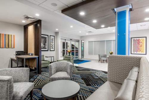 a lobby with a couch and chairs and a table at Holiday Inn Express & Suites - Punta Gorda by IHG in Punta Gorda