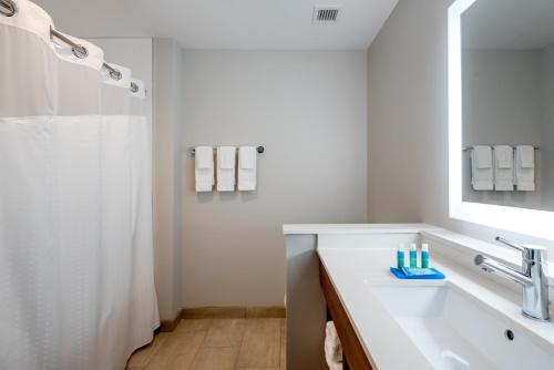 a white bathroom with a sink and a mirror at Holiday Inn Express & Suites - Punta Gorda by IHG in Punta Gorda