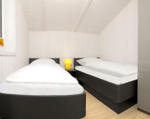 - 2 lits dans une chambre aux murs blancs dans l'établissement Dänische Ferienhäuser am Salzhaff Haus Im Wiesengrund, à Poel