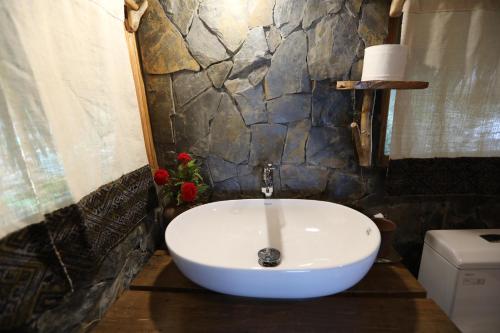 a white sink in a bathroom with a stone wall at Lua Pu Luong in Pu Luong