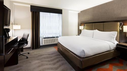 ein Hotelzimmer mit einem Bett, einem Schreibtisch und einem TV in der Unterkunft Holiday Inn Lower East Side, an IHG Hotel in New York