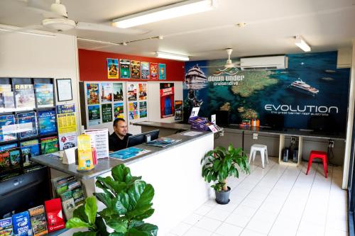 a man sitting at a counter in a store at The Jack Backpackers in Cairns