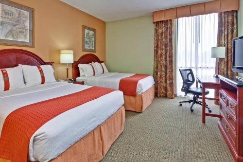 um quarto de hotel com duas camas e uma televisão em Holiday Inn Memphis-University of Memphis, an IHG Hotel em Memphis