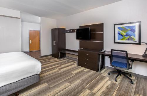 a hotel room with a bed and a desk with a computer at Holiday Inn Express & Suites Morristown by IHG in Morristown