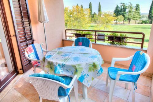 a table and chairs on a balcony with a view of a field at Apartment Josip 2011 in Fažana