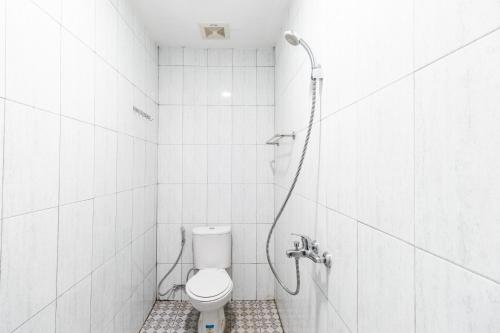 La salle de bains est pourvue d'une douche et de toilettes. dans l'établissement RedDoorz near Medan Amplas, à Delitua