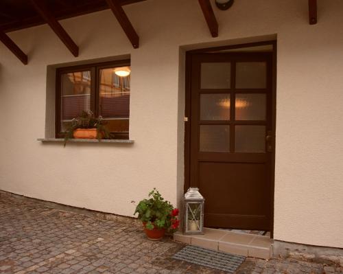 a front door of a house with a plant and a lantern at Ferienwohnung Liebeskind in Hopfgarten