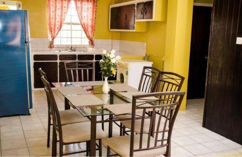 a kitchen with a dining room table and chairs at Aanola Villas A3 Quietude Domicile in Charlotte