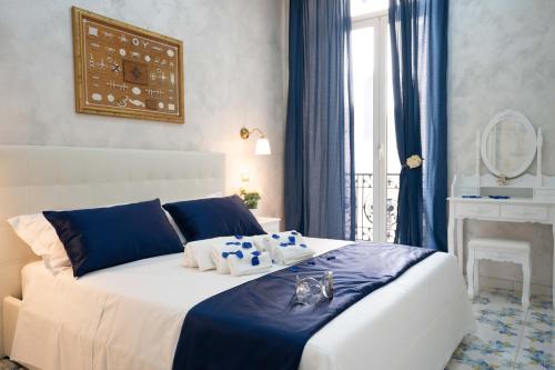 a bedroom with a large bed with blue and white at Alma Adry in Naples