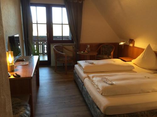 a hotel room with two beds and a desk at See-Hotel Storchenmuehle in Fichtenau