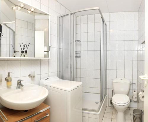 y baño con lavabo, aseo y ducha. en Appartement Mien to hus, en Kirchdorf