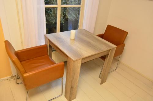 een houten tafel met twee stoelen en een kaars erop bij Bed and Breakfast de Kleyne Wereld in Vlissingen