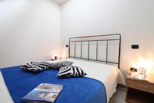 ein Bett mit zwei Kissen und eine Zeitschrift darauf in der Unterkunft Casa vacanze arianna Otranto centro, Salento 6 posti in Otranto