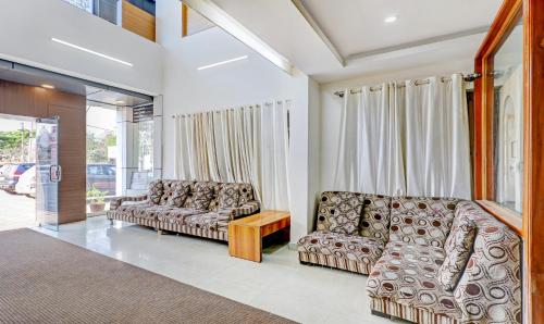 a living room with two couches and a table at Treebo Atithi Comforts, 1 Km From Nisargadhama Forest in Kushālnagar