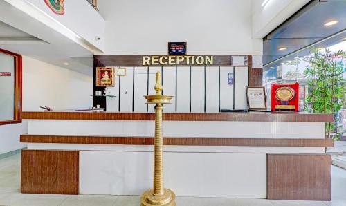 a hotel lobby with a reception counter and stairs at Treebo Atithi Comforts, 1 Km From Nisargadhama Forest in Kushālnagar