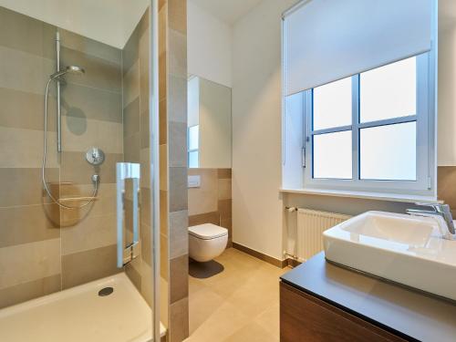 uma casa de banho com um lavatório, um chuveiro e um WC. em Apartment:house Klosterbau em Neutraubling