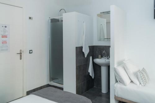 y baño con ducha y lavamanos. en Gran Via 63 Rooms en Madrid