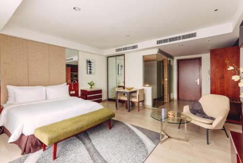 a bedroom with a bed and a table and a chair at SILA Urban Living in Ho Chi Minh City