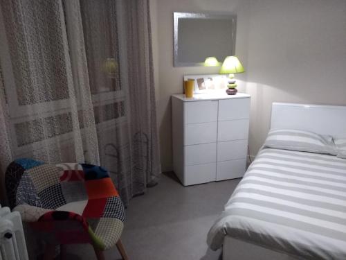 a bedroom with a bed and a dresser and a mirror at Le Clos Domenat 3 in Brive-la-Gaillarde