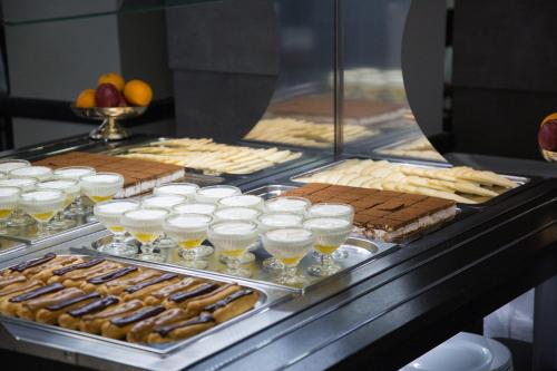 a buffet line with various pastries and drinks at Hôtel National in Lourdes
