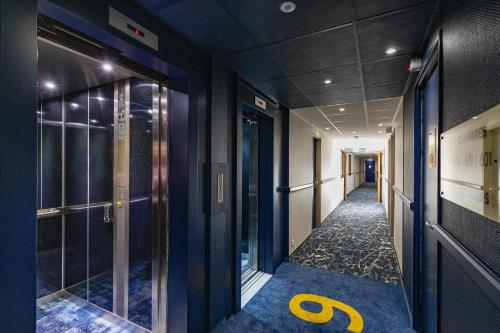 a hallway with blue walls and a yellow number on the floor at Hôtel National in Lourdes