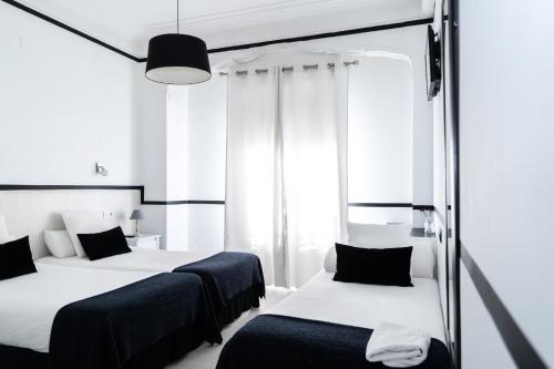 a hotel room with two beds and two lamps at Gran Via 63 Rooms in Madrid