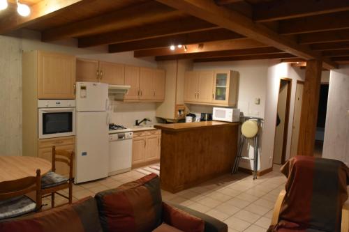 uma cozinha com um frigorífico branco e uma mesa em chez nous em Chilhac