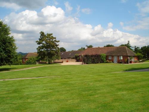 a house with a large green field in front of it at Three Chimneys Farm Accommodation in Goudhurst