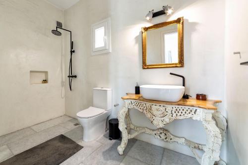 a bathroom with a sink and a toilet and a mirror at Villa Pela in Aliki