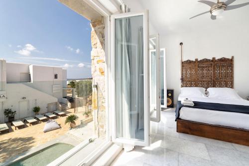 a bedroom with a bed and a large window at Villa Pela in Aliki