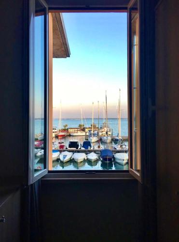 a window with a view of a harbor with boats at Albergo La Pescatrice in Moniga