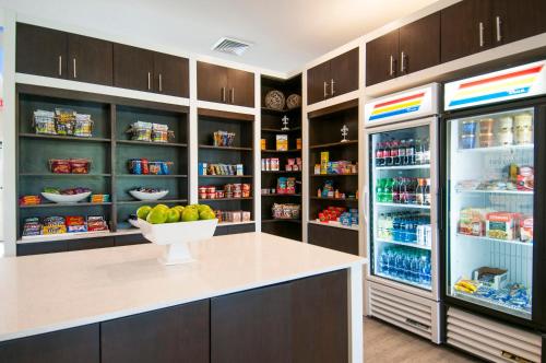 a kitchen with an open refrigerator with a bowl of fruit at Holiday Inn - New Orleans Airport North by IHG in Kenner