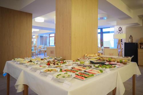 a long table with plates of food on it at HOTEL*** NAT Bukowina Tatrzańska in Bukowina Tatrzańska