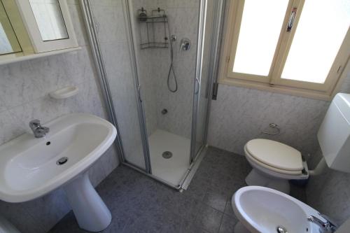 bagno con doccia, lavandino e servizi igienici di Villetta Sonia a Lignano Sabbiadoro