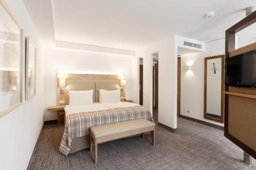 a hotel room with a bed and a flat screen tv at Holiday Inn Nürnberg City Centre by IHG in Nürnberg