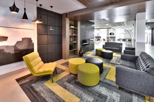 a living room with yellow and gray chairs and tables at Holiday Inn Express & Suites - Trois Rivieres Ouest by IHG in Trois-Rivières