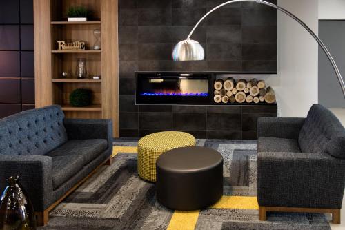 a living room with two chairs and a fireplace at Holiday Inn Express & Suites - Trois Rivieres Ouest by IHG in Trois-Rivières