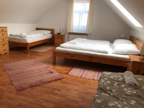 a bedroom with two beds and a rug at Boróka Vendégház in Matrakeresztes