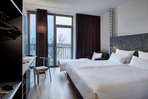 a hotel room with two beds and a large window at INNSiDE by Meliá Bremen in Bremen