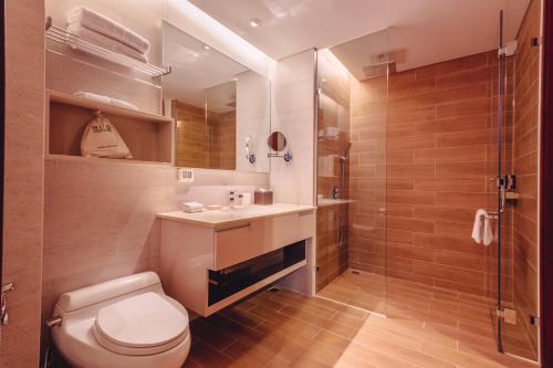 a bathroom with a toilet and a sink and a shower at SILA Urban Living in Ho Chi Minh City