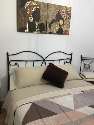 1 dormitorio con 1 cama con una foto en la pared en Chalet El Descanso en Rades de Abajo