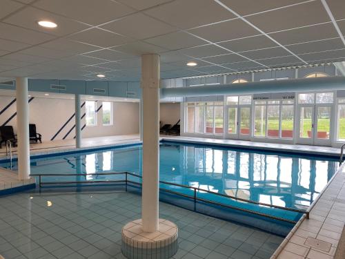 een groot zwembad in een groot gebouw bij Appartement, Amelander Kaap 121 in Hollum